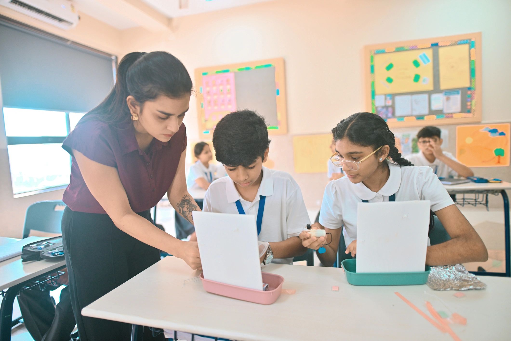 Teacher guiding students during hands-on STEM activity